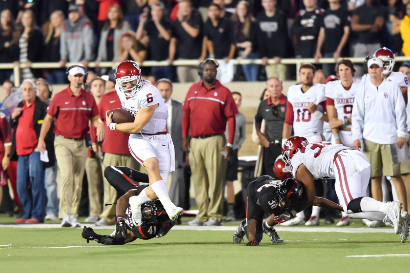 Oklahoma quarterback Baker Mayfield breaks the tackle of Texas Tech's Malik Jenkins.