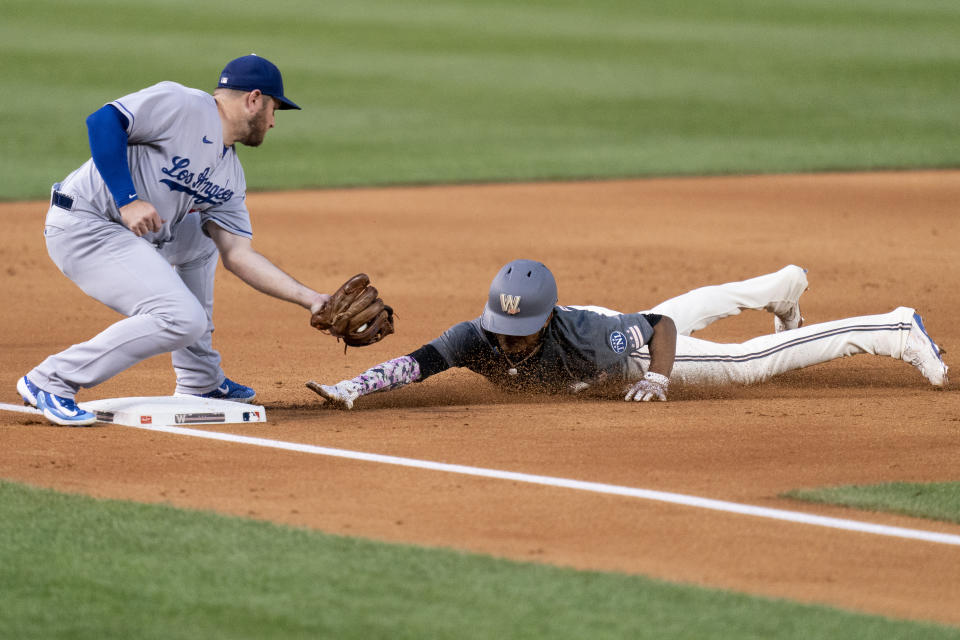 Washington Nationals' CJ Abrams, right, steals third in front of Los Angeles Dodgers third baseman Max Muncy, left, during the first inning of a baseball game, Friday, Sept. 8, 2023, in Washington. (AP Photo/Stephanie Scarbrough)
