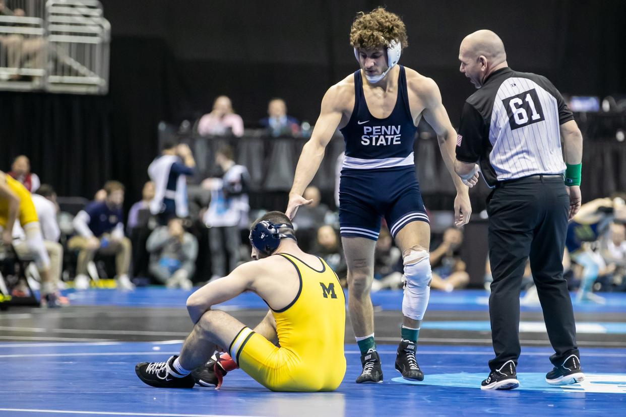 Mar 22, 2024; Kansas City, MO, USA; Mitchell Mesenbrink of Penn State goes to help up Cameron Amine of Michigan after his victory during the quarterfinal of the Men’s Division I NCAA Wrestling Championships at T-Mobile Center. Mandatory Credit: Nick Tre. Smith-USA TODAY Sports