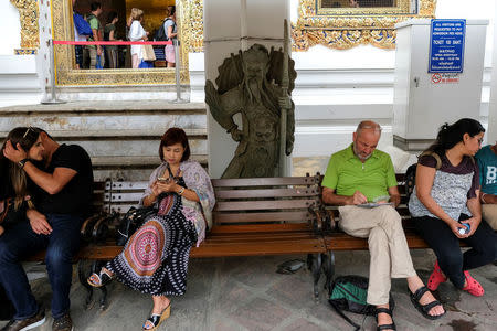 A Chinese tourist takes a break at Wat Pho in Bangkok, Thailand, January 11, 2017. REUTERS/Athit Perawongmetha