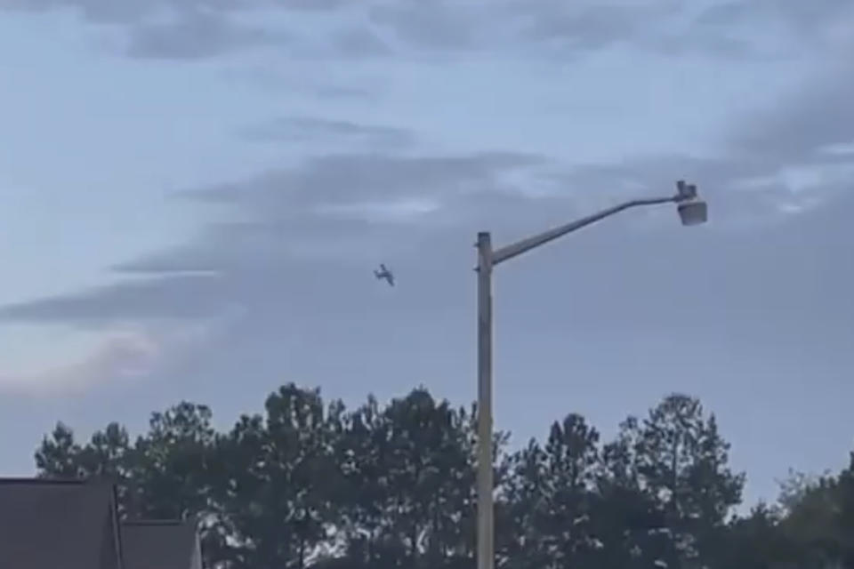 A small airplane circles over Tupelo, Miss., on Saturday, Sept. 3, 2022. Police say the pilot of the small airplane is threatening to crash the aircraft into a Walmart store. The Tupelo Police Department said that the Walmart and a nearby convenience store had been evacuated. (WCBI-TV via AP)