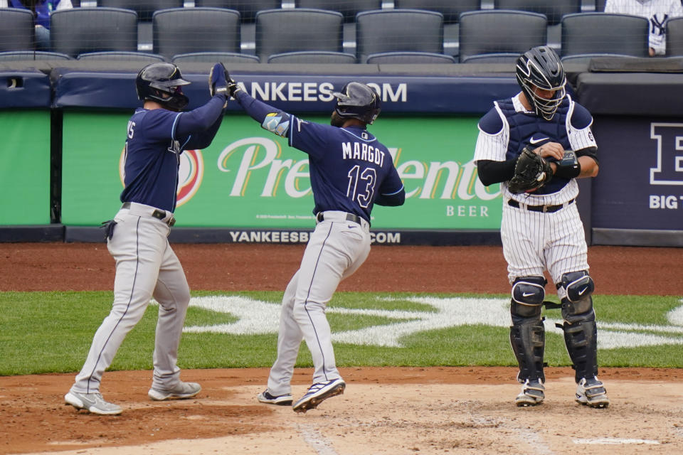 New York Yankees catcher Gary Sanchez, right, reacts as Tampa Bay Rays' Manuel Margot, center, celebrates with Austin Meadows after they scored on a two-run home run by Margot during the fourth inning of a baseball game Saturday, April 17, 2021, in New York.(AP Photo/Frank Franklin II)