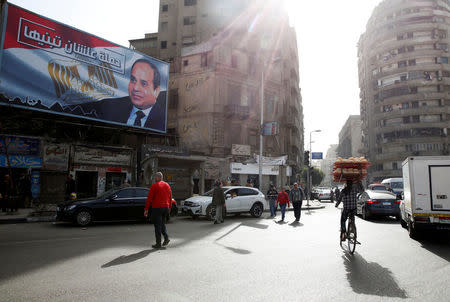 People walk by a poster of Egypt's President Abdel Fattah al-Sisi from the campaign titled “Alashan Tabneeha” (So You Can Build It), for the upcoming presidential election in Cairo, Egypt, January 22, 2018. REUTERS/Amr Abdallah Dalsh
