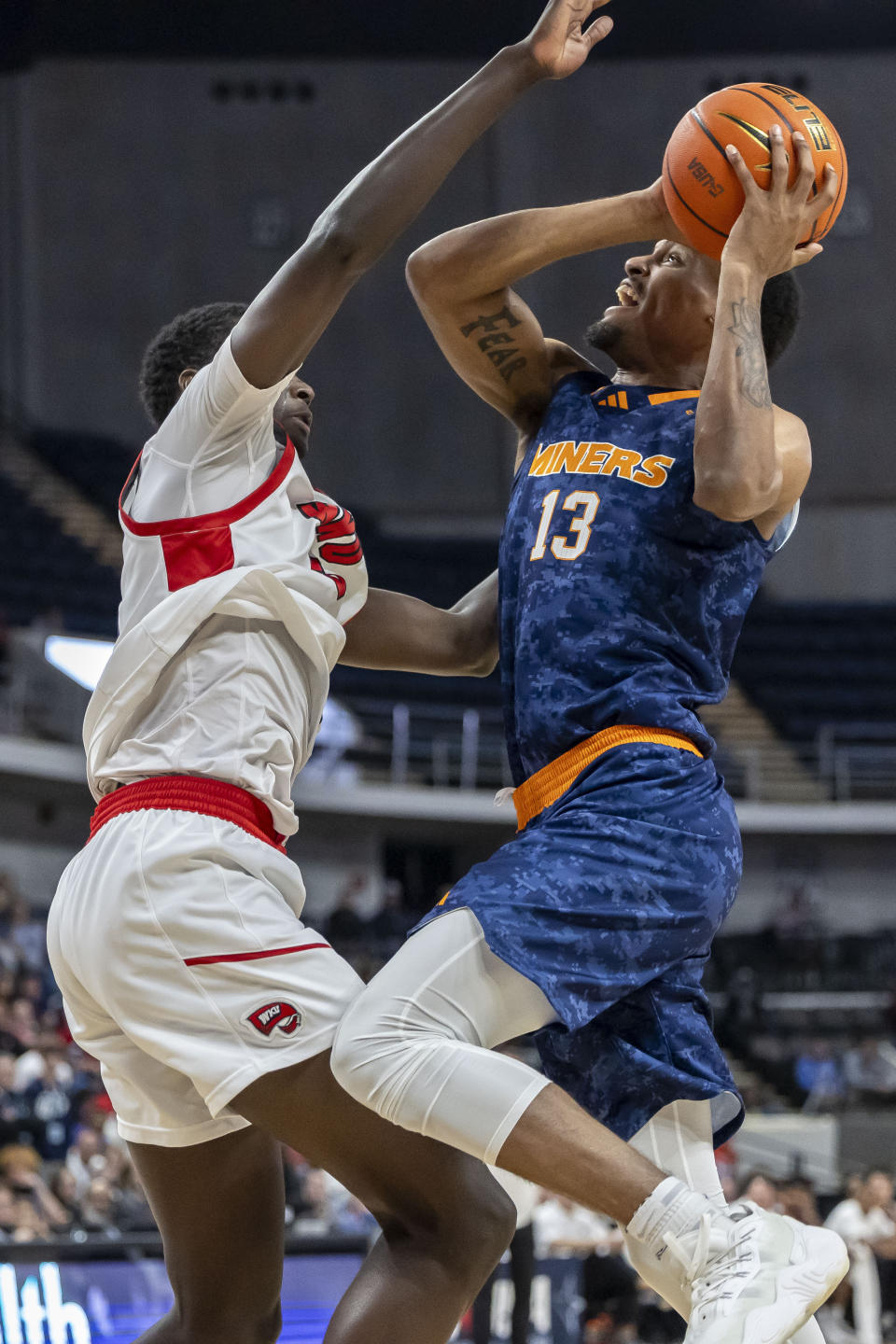 UTEP forward Calvin Solomon (13) challenges Western Kentucky forward Babacar Faye (5) during the first half of an NCAA college basketball game at the Conference USA Tournament final, Saturday, March 16, 2024, in Huntsville, Ala. (AP Photo/Vasha Hunt)