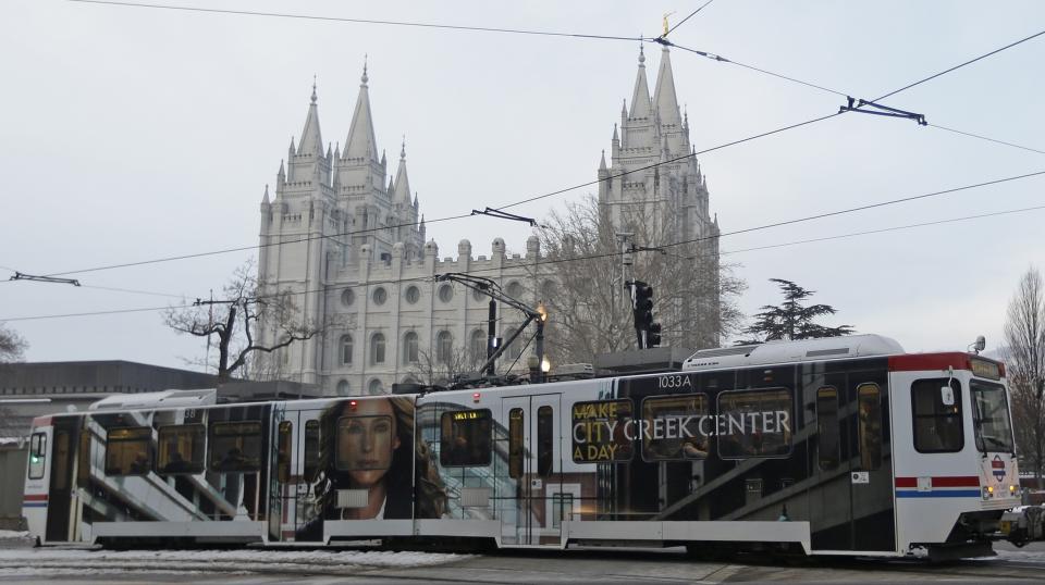 The downtown light rail rolls pass The Salt Lake Temple Wednesday, Jan. 9, 2013, in Salt Lake City. Built with the 2002 Winter Olympics in mind, Salt Lake City’s light-rail network is free for passengers as it weaves through downtown. Riders can get to and from major attractions such as Temple Square, City Creek Center, Salt Lake City Library, Energy Solutions Arena and the Gateway for free. An extension leading to the airport is expected to open this spring, but that trips on that section will cost riders. (AP Photo/Rick Bowmer)