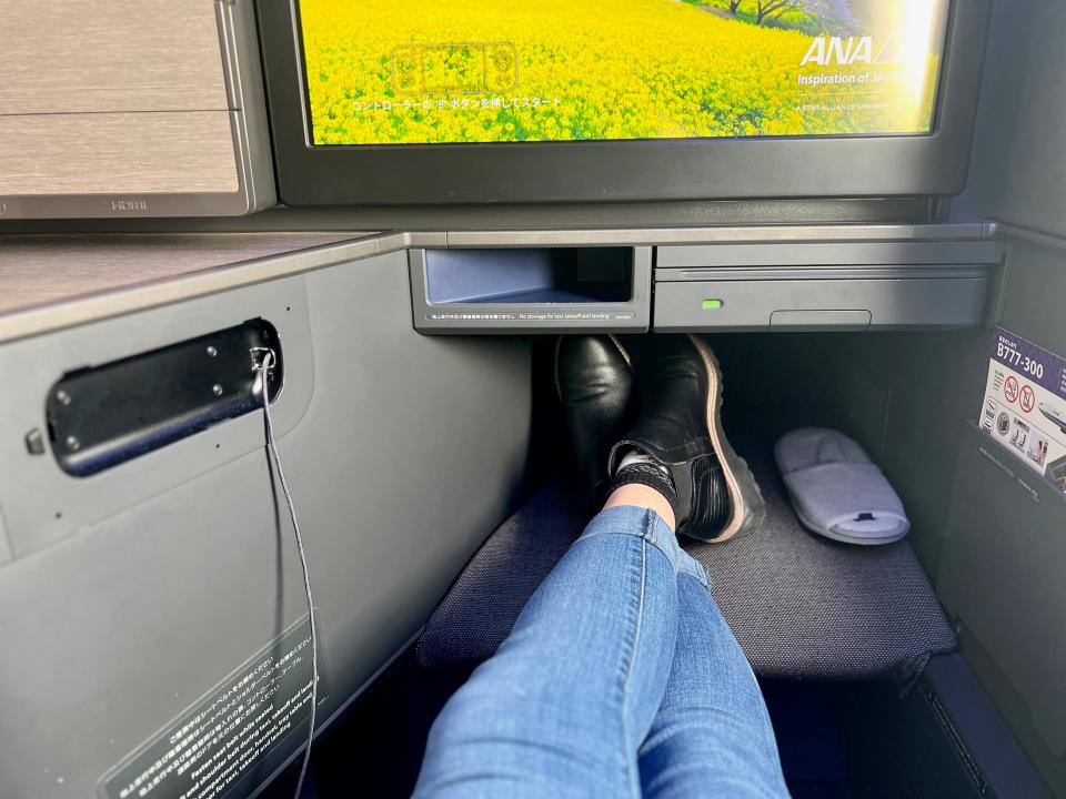 The author's legs on the footrest under the TV.