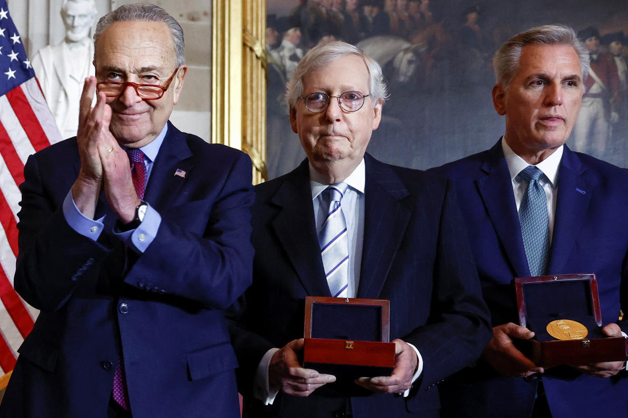 Senate Majority Leader Chuck Schumer applauds, as Senate Minority Leader Mitch McConnell and House Minority Leader Kevin McCarthy each hold a wooden box containing a medal, at a Congressional Gold Medal ceremony