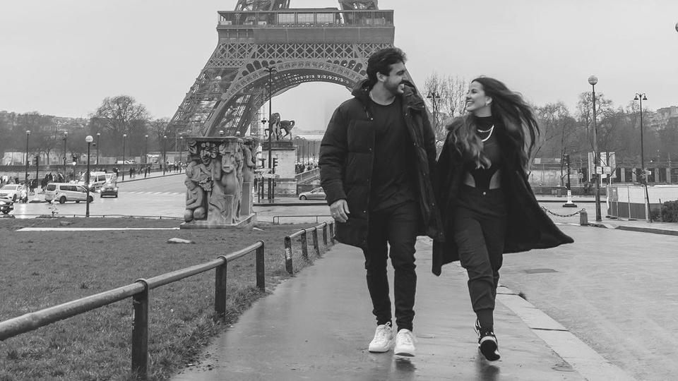 Luana Andrade and João Hadad strolling past the Eiffel Tower