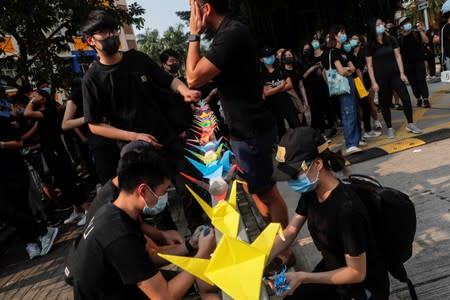 Alumni of Tsuen Wan Public Ho Chuen Yiu Memorial College arrange paper cranes at a student gathering in the school in solidarity with the student protester who was shot by a policeman on Tuesday in Tsuen Wan