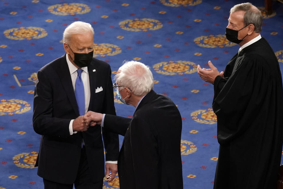 President Joe Biden greets Sen. Bernie Sanders, I-Vt., as Chief Justice of the United States John Roberts watches as Biden arrives to speak to a joint session of Congress Wednesday, April 28, 2021, in the House Chamber at the U.S. Capitol in Washington. (AP Photo/Andrew Harnik, Pool)