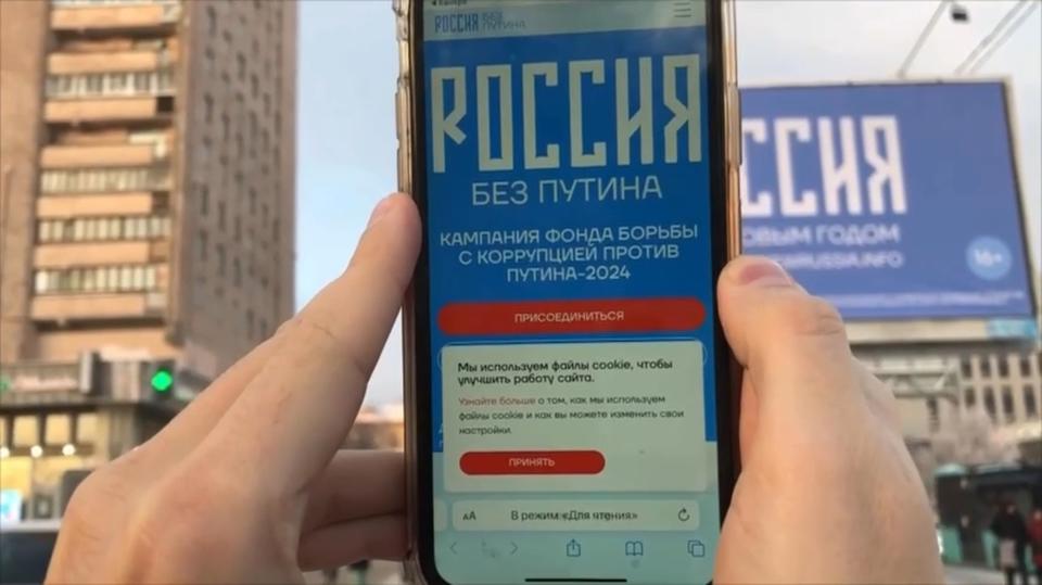 This photo taken from video released by telegram channel Navalny's team on Thursday, Dec. 7, 2023, shows as a person points a smartphone at a billboard with the words Happy New Year and the QR code in St. Petersburg, Russia. The Anti-Corruption Foundation, which was set up by jailed opposition leader Alexey Navalny, took out billboards in Moscow, St Petersburg and other cities which wished Russians a Happy New Year. But the website on the posters and the QR code led to a website with their campaign against the president called 'Russia without Putin,' in which the group call on Russians to vote against him in the March 17 election. (telegram channel Navalny's team via AP)