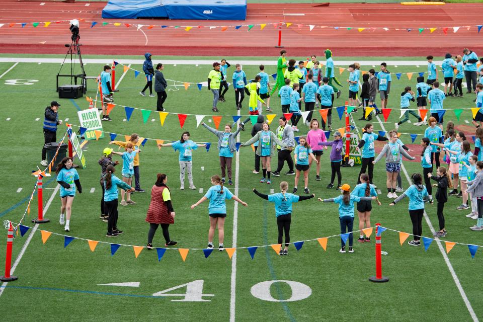 Middle and high school participants warm up before their race during the 2024 Awesome 3000.
