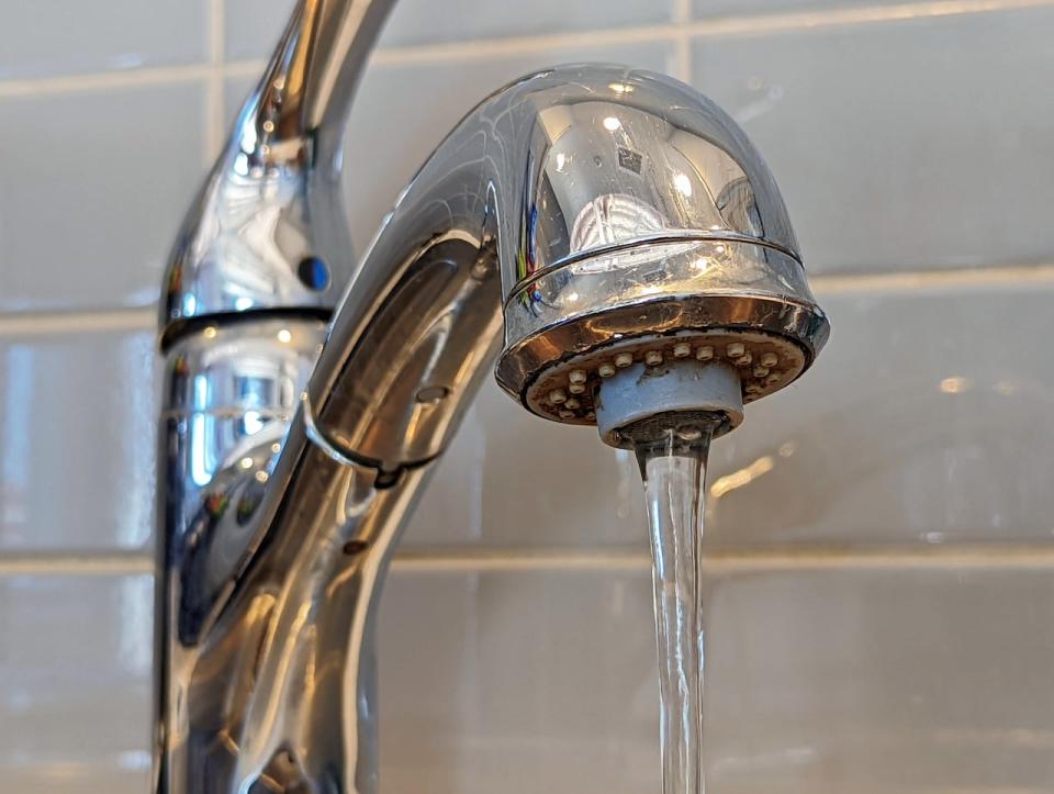 Water pours out of a tap in CBC Nunavut's kitchen in Iqaluit on March 1, 2022.