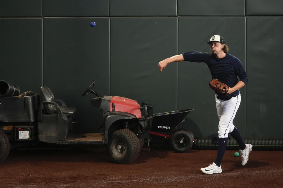 Seattle Mariners pitcher Logan Gilbert warms up with a weighted ball before a baseball game against the Minnesota Twins, Sunday, June 30, 2024, in Seattle. Velocity training is the rage in baseball from the youth levels up through the majors. Players go through specialized programs – often using series of progressively weighted baseballs – in the hopes of speeding up their bodies and arms, pushing them to the limits of what might be possible for their age and ability. (AP Photo/Lindsey Wasson)