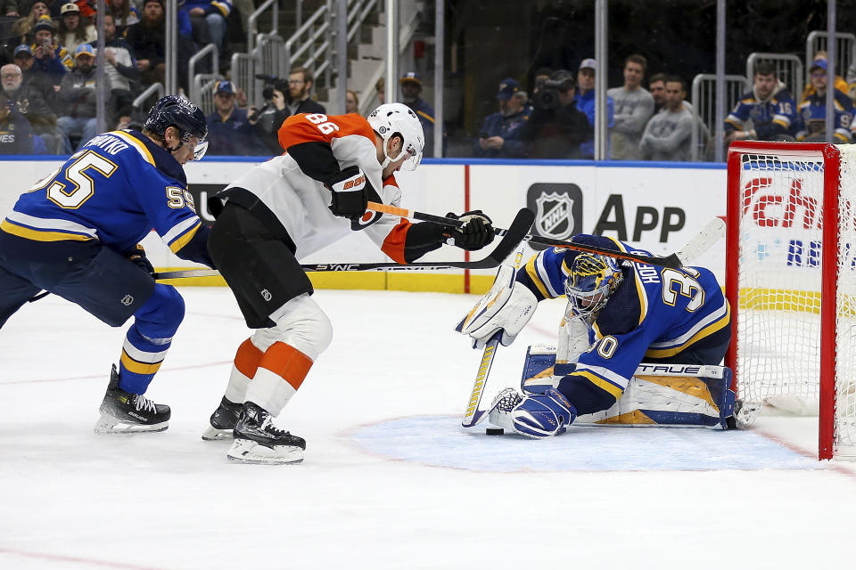 St. Louis Blues goaltender Joel Hofer (30) and Colton Parayko (55) defend against Philadelphia Flyers' Joel Farabee (86) during the first period of an NHL hockey game Monday, Jan. 15, 2024, in St. Louis. (AP Photo/Scott Kane)