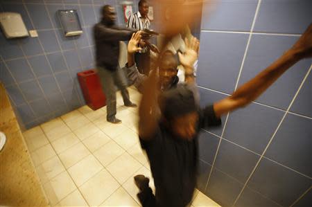 Armed police search customers taking cover inside a bathroom while combing through the Westgate shopping centre for gunmen in Nairobi, September 21, 2013. REUTERS/Goran Tomasevic