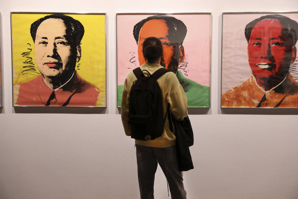 Kourosh Aminzadeh, a student of graphics, looks at China's late leader, Mao Zedong painting series by American artist Andy Warhol at Tehran Museum of Contemporary Art in Tehran, Iran on Oct. 19, 2021. Iranians are flocking to Tehran's contemporary art museum to marvel at American pop artist Andy Warhol’s iconic work. (AP Photo/Vahid Salemi)