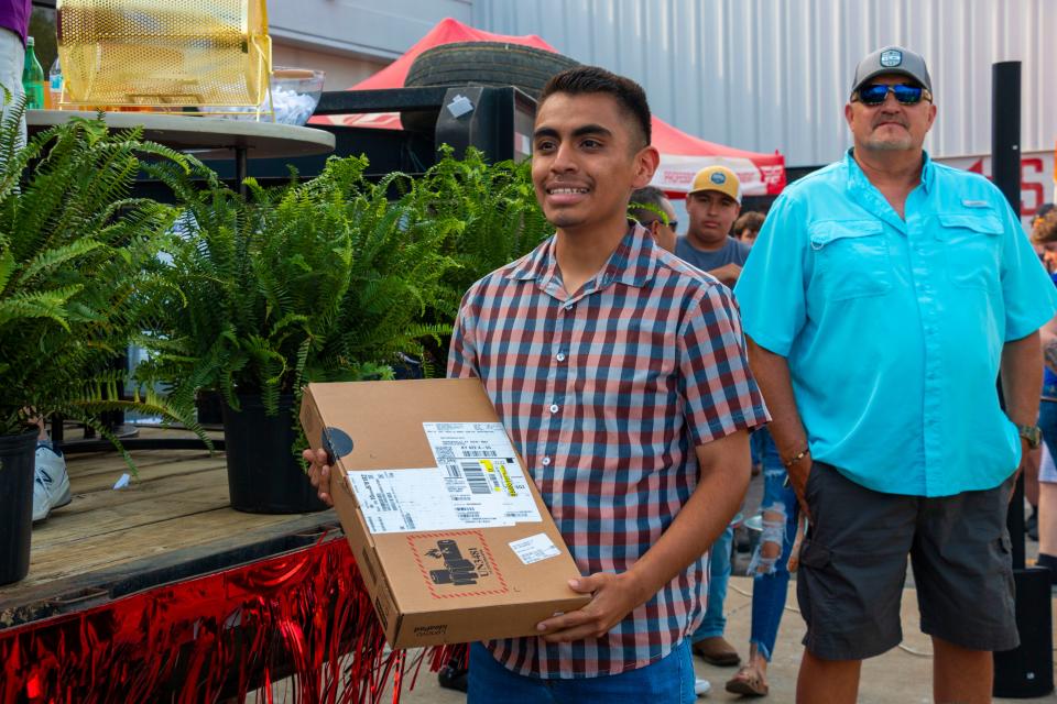 Erik Nieto-Vasquez holds his brand new laptop on Saturday, May, 21, 2022, during the Strive to Drive giveaway held in Columbia.