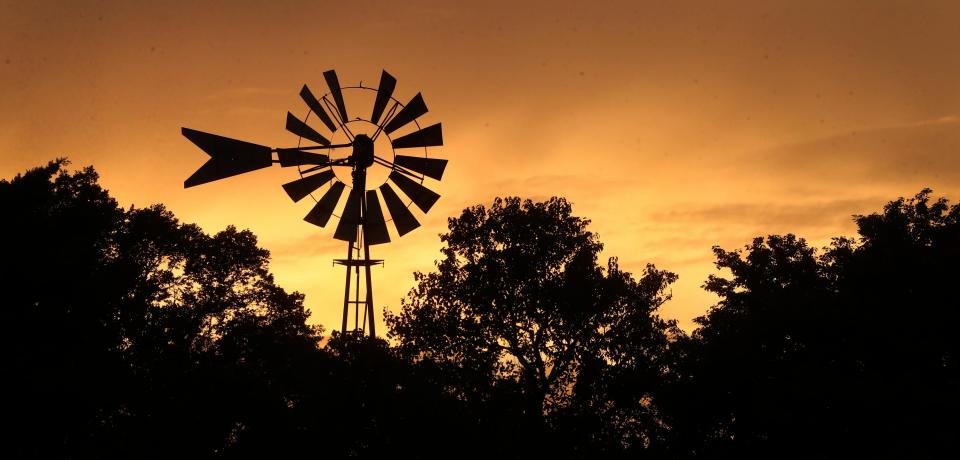 The sun sets at Cannonsburgh Village silhouetting the windmill at the village on Tuesday, Sept. 12, 2023.