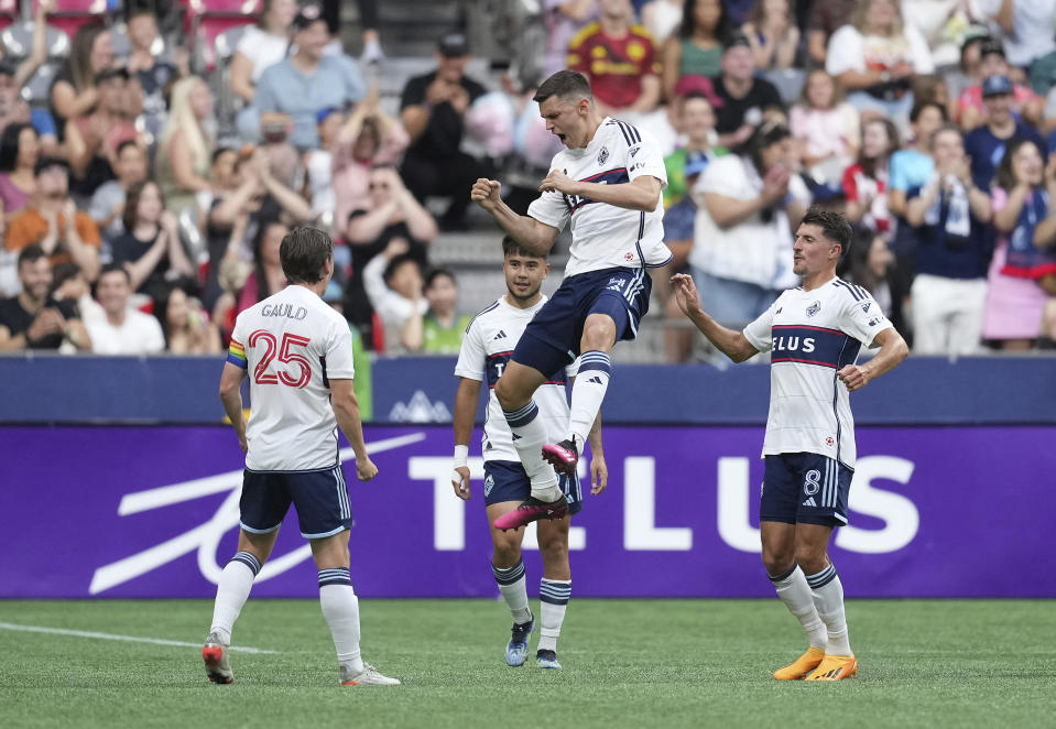 Vancouver Whitecaps' Ranko Veselinovic, top, celebrates his goal against the Seattle Sounders with Ryan Gauld (25), Alessandro Schopf (8) and Ryan Raposo, back, during the first half of an MLS soccer match Saturday, July 8, 2023, in Vancouver, British Columbia. (Darryl Dyck/The Canadian Press via AP)