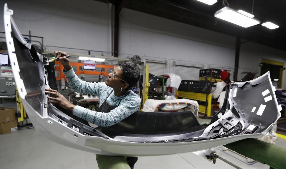 FILE- Mary Skinner inspects the rear end of a General Motors Chevrolet Cruze at Jamestown Industries in Youngstown, Ohio on Nov. 28, 2018. U.S. automakers and parts manufacturers have added nearly 90,000 jobs since January 2020 but it's hard to tease out just which economic gains can be credited to USMCA and which happened for a variety of unrelated reasons. (AP Photo/Tony Dejak, File)