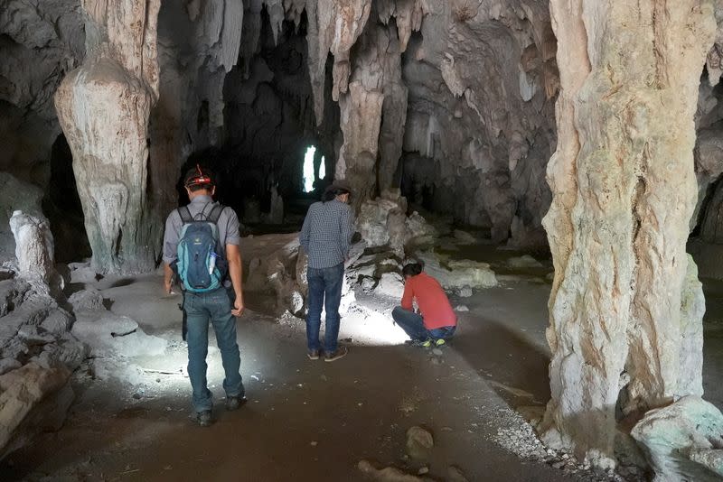 Archaelogists visit the Leang Panninge cave during a research for ancient stones in Maros regency