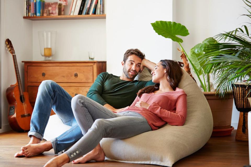 A couple sits on their sofa and talks