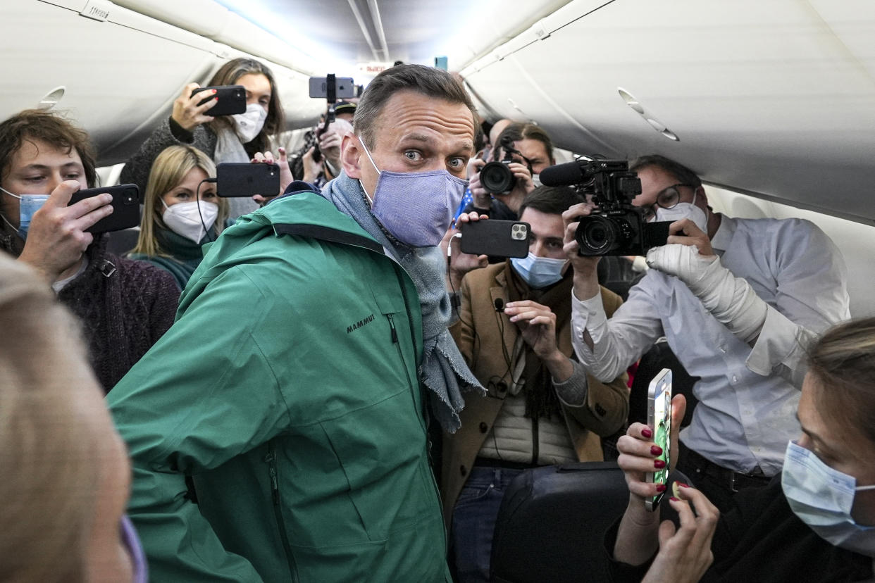 FILE - Alexei Navalny is surrounded by journalists in a plane before a flight to Moscow in the Berlin Brandenburg Airport on Sunday, Jan. 17, 2021. Over the past 12 months, scores of activists, independent journalists and rights advocates have been targeted with raids, detained and designated as terrorists and foreign agents. In a span of a decade, Navalny has gone from the Kremlin's biggest foe to Russia's most prominent political prisoner. Already serving two convictions that have landed him in prison for at least nine years, he faces a new trial that could keep him behind for another two decades. AP Photo/Mstyslav Chernov, File)