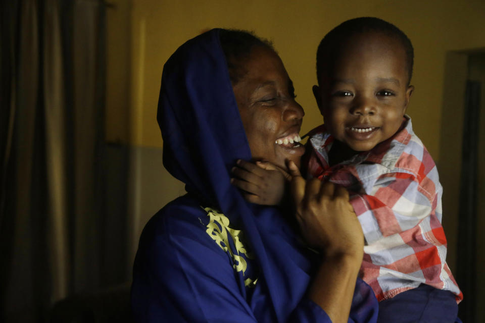 FILE - Amina Ahmed, the wife of Muhammad Mubarak Bala, an atheist who has been detained since April 2020, plays with her son, Sodangi Mubarak, in her home in Abuja, Nigeria, Sunday, Nov. 21, 2021. She went to see him most recently with their 3-year-old son who was only six weeks old when Bala was taken into custody. He is in good spirits, Ahmed said of her husband. But it has been difficult for her, beginning when she was healing from childbirth while her husband remained behind bars. (AP Photo/Sunday Alamba, File)