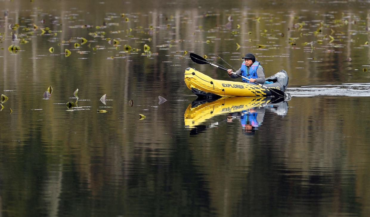 Richard Tanaka, of Poulsbo, paddles to the shore after spending the morning fishing at Bremerton’s Kitsap Lake on April 26.