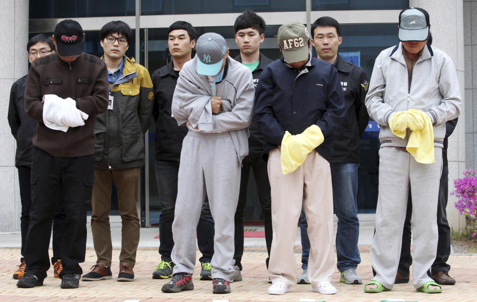 Crew members of sunken ferry Sewol prepare to leave a court which issued their arrest warrant, in Mokpo, South Korea, Saturday, April 26, 2014. All 15 people involved in navigating the South Korean ferry that sank and left scores of people dead or missing are now in custody after authorities on Saturday detained four more crew members, a prosecutor said. (AP Photo/Yonhap) KOREA OUT