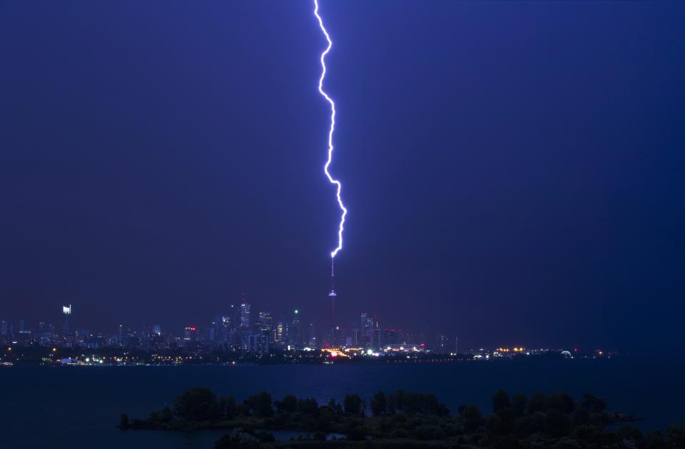 A lightning bolt strikes the CN Tower during an electrical storm in Toronto, Thursday, July 14, 2016. Heavy winds and rain brought down trees and power lines overnight in Toronto. (Mark Blinch/The Canadian Press via AP)