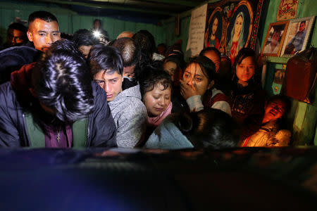 Family members mourn around a coffin carrying the body of Misael Paiz, 25, at a wake inside his family home in Aguacate, Huehuetenango, Guatemala, October 28, 2018. REUTERS/Lucy Nicholson