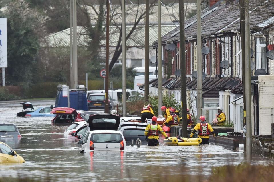 A member of the public is rescued after flooding in Nantgarw, Wales: PA