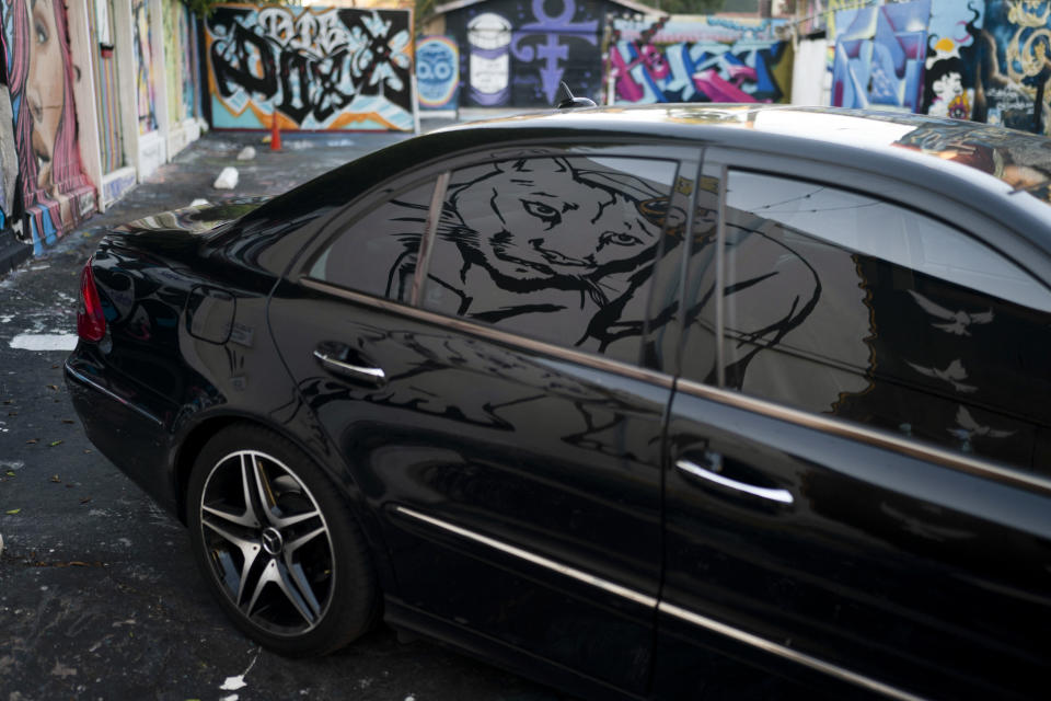 A mural depicting the famed mountain lion known as P-22 is reflected in a car window in Los Angeles, Friday, Jan. 20, 2023. The popular puma gained fame as P-22 and shone a spotlight on the troubled population of California's endangered mountain lions and their decreasing genetic diversity. But it's the big cat's death — and whether to return his remains to ancestral tribal lands where he spent his life — that could posthumously give his story new life. (AP Photo/Jae C. Hong)