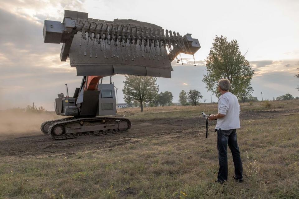 A man using a remote control demonstrates an up-armored excavator for demining purposes, in Kryvyi Rig on Sept.15, 2023, amid the Russian invasion of Ukraine. Ukraine has huge areas scattered with mines placed by departing Russian troops, as well as unexploded shells and missiles, which could take many years to clear. (Photo by Roman Pilipey / AFP via Getty Images)
