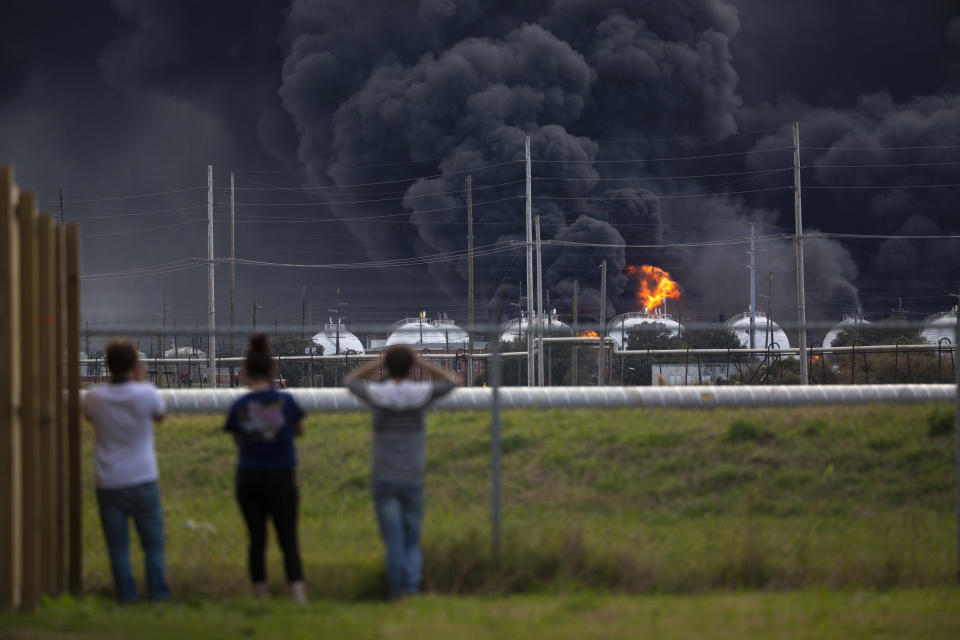 Residents observe the fire consuming the TPC Group plant on Wednesday, Nov. 27, 2019, in Port Neches, Texas. Two massive explosions 13 hours apart tore through the chemical plant Wednesday, and one left several workers injured. (Marie D. De Jesús/Houston Chronicle via AP)