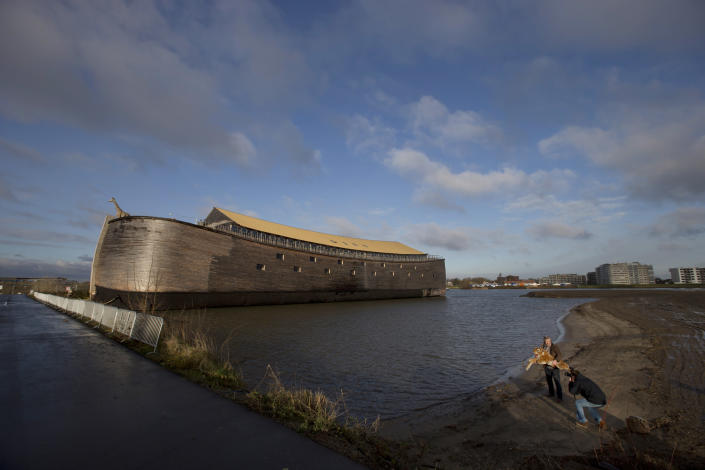 Johan Huibers, bottom right, poses, after being asked by a photographer to go outside, with a stuffed tiger in front of the full scale replica of Noahís Ark in Dordrecht, Netherlands, Monday Dec. 10, 2012. (AP Photo/Peter Dejong)