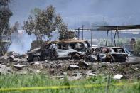 <p>Charred vehicles are seen at the site of a series of explosions at fireworks warehouses in Tultepec, central Mexico, on July 5, 2018. – At least 19 people were killed, including rescue workers who died saving others’ lives, officials said. The initial explosion occurred around 9:30 am (1430 GMT), then spread to other warehouses just as police and firefighters began attending to the first victims. (Photo: Pedro Pardo/AFP/Getty Images) </p>