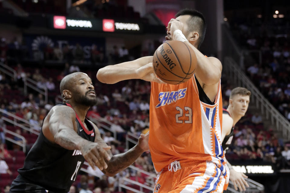 Houston Rockets forward P.J. Tucker, left, knocks the ball away from Shanghai Sharks center Zhang Zhaoxu (23) during the first half of an NBA basketball preseason game Monday, Sept. 30, 2019, in Houston. (AP Photo/Michael Wyke)