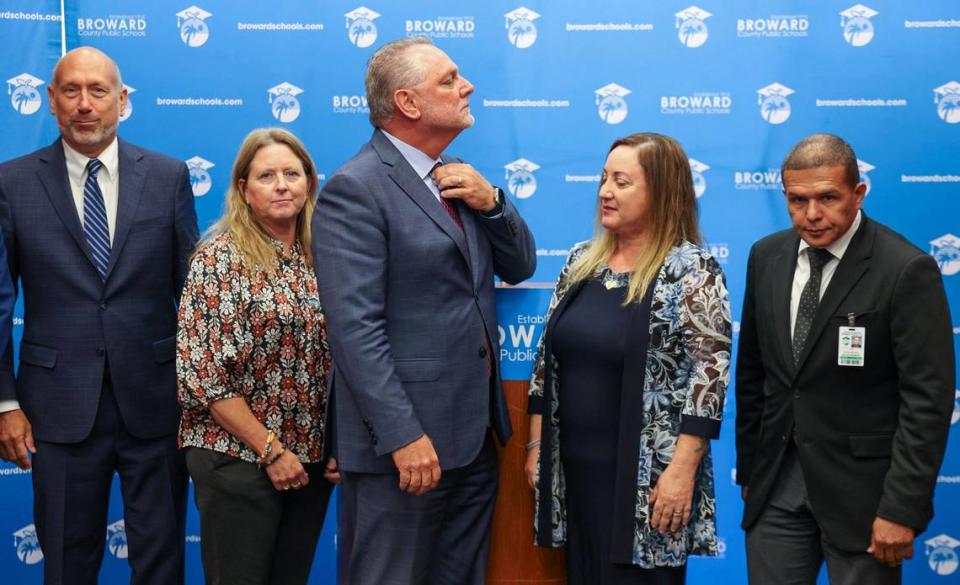 Superintendent Peter Licata, center, adjusts his tie prior to taking the first official photo with members of the Broward School Board, Tuesday, July 11, 2023. Left to right: School Board members Allen Zeman, Vice Chair Debra Hixon, Licata, Board Chair Lori Alhadeff and Jeff Holness.