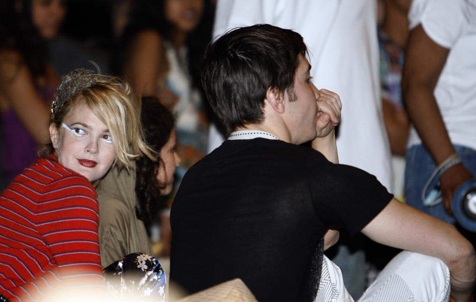 Actress Drew Barrymore (L) sits next to actor Justin Long before the M.I.A. performance at the Coachella Music Festival in Indio, California April 18, 2009.  REUTERS/Mario Anzuoni   (UNITED STATES ENTERTAINMENT)