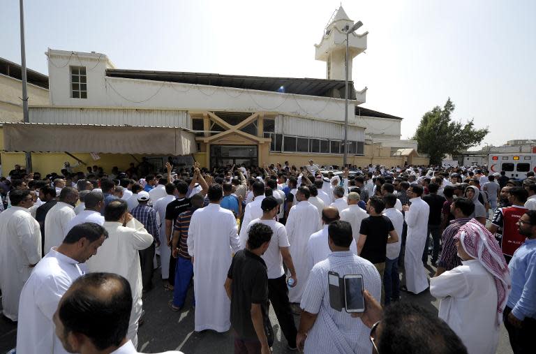 Saudi men gather outside a mosque that was targeted with a blast in the coastal town of Qatif, on May 22, 2015