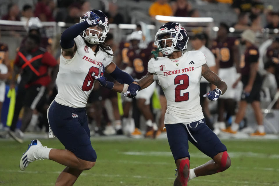 Fresno State defensive back Carlton Johnson (2) celebrates with linebacker Levelle Bailey after intercepting an Arizona State pass during the second half of an NCAA college football game Saturday, Sept. 16, 2023, in Tempe, Ariz. (AP Photo/Rick Scuteri)