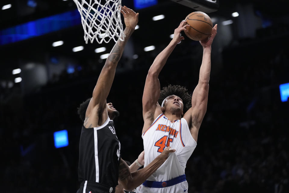 New York Knicks center Jericho Sims (45) and Brooklyn Nets center Nic Claxton (33) reach for a rebound during the first half of an NBA basketball game, Tuesday, Jan. 23, 2024, in New York. (AP Photo/Mary Altaffer)