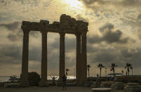 Tourists visit the 150AD Roman temple dedicated to Apollo the Greek and Roman god of music, harmony and light, in Antalya, southern Turkey, on Sunday, June 20, 2021. Hotels in Turkey's Antalya region, a destination beloved by holidaymakers, are preparing to finally resume operations as they expect the return of international tourists after months of setbacks caused by the pandemic that halted travel. (AP Photo/Emrah Gurel)