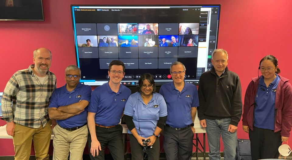 Members of the JPL team pose after the first streamed ultra-HD video was received from deep space. Remote team members (including Taters the cat) appear on the meeting screen. Standing, from left, are: Dan Goods, Abi Biswas, Ryan Rogalin, Meera Srinivasan, Bill Klipstein, Oliver Lay, and Christine Chen.<br> Credit: NASA/JPL-Caltech