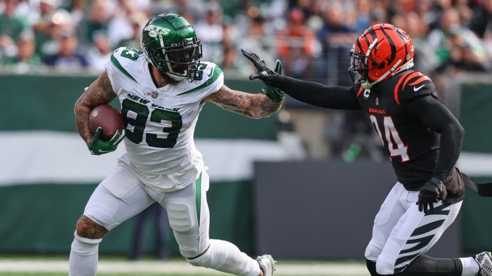 New York Jets tight end Tyler Conklin (83) runs with the ball while Cincinnati Bengals safety Vonn Bell (24) attempts to tackle him.