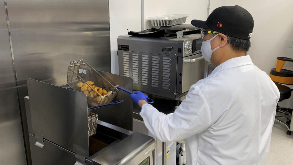 Nathan Foot, R&D chef at Impossible Foods, takes its new meatless nuggets out of a deep fryer in the company’s test kitchen on Sept. 21, 2021 in Redwood City, Calif. The plant-based nuggets taste are designed to taste like chicken. (AP Photo/Terry Chea)