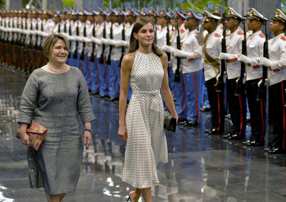 Spain's Queen Letizia, center, walks with Lis Cuesta Peraza, wife of Cuban President Miguel Diaz-Canel, after a review of an honor guard at Revolution Palace in Havana, Cuba, Tuesday, Nov. 12, 2019. (Yamil Lage/Pool photo via AP)